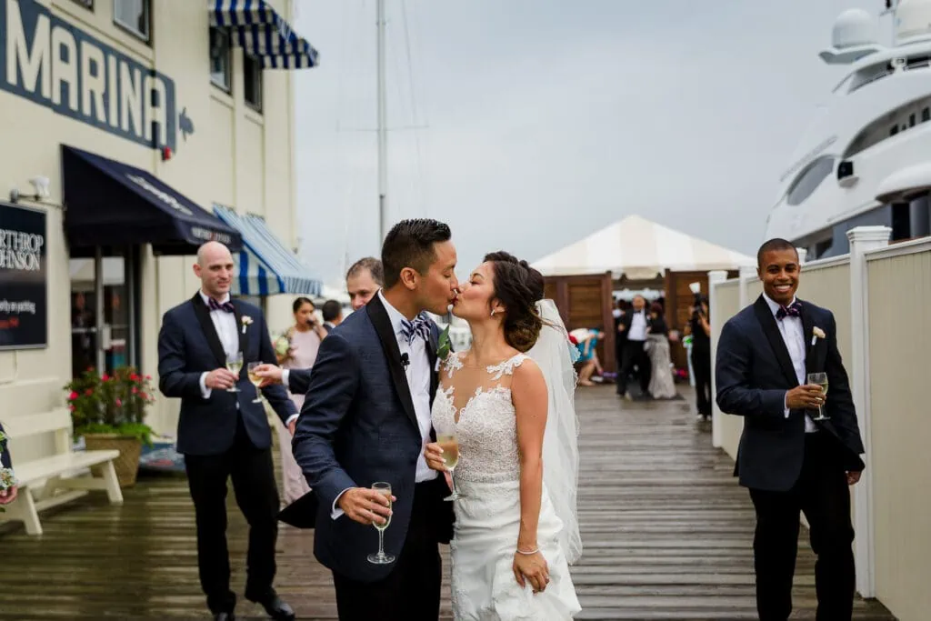 A bride and groom kiss on the dock at Regatta Place after their wedding ceremony