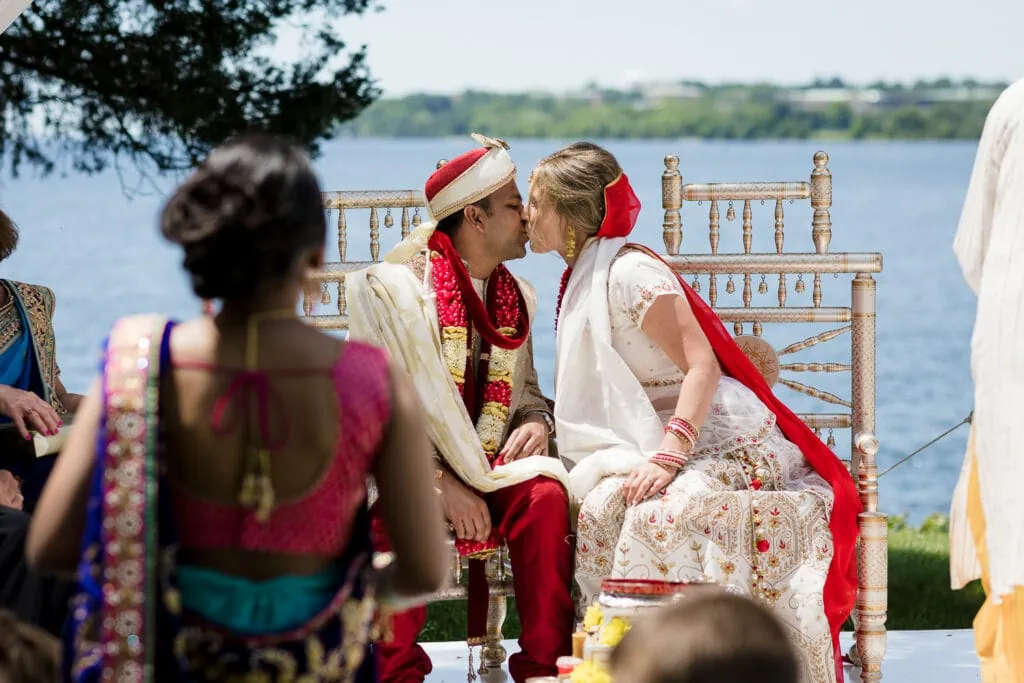 A bride and groom kiss under the mandap at an indian fusion wedding in rhode island