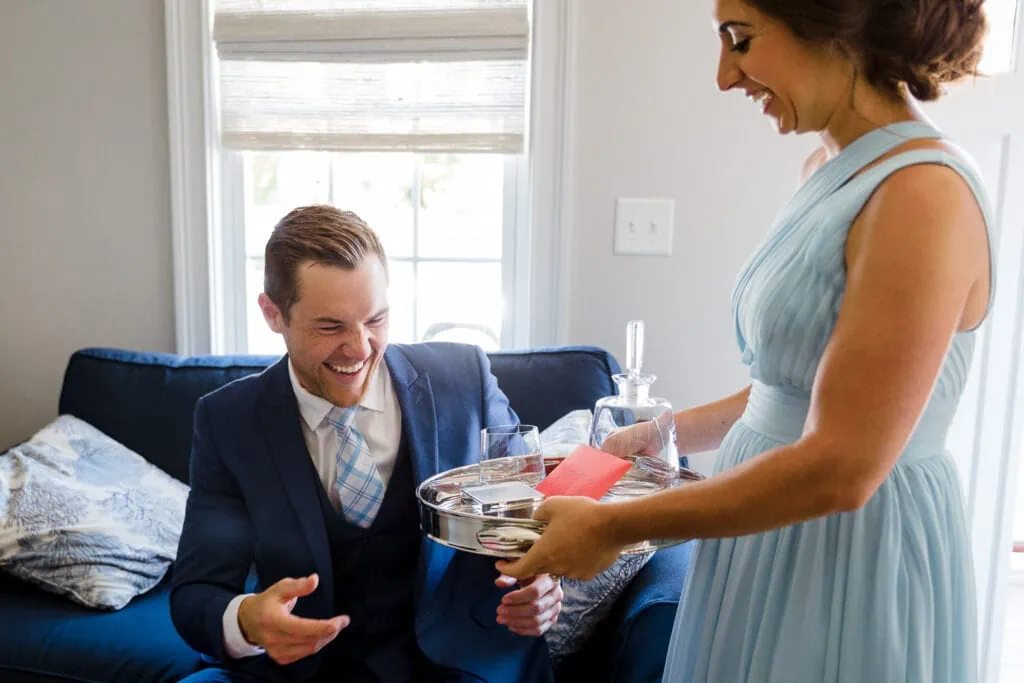 A bridesmaid in light blue delivering a tray to a man in a blue suit