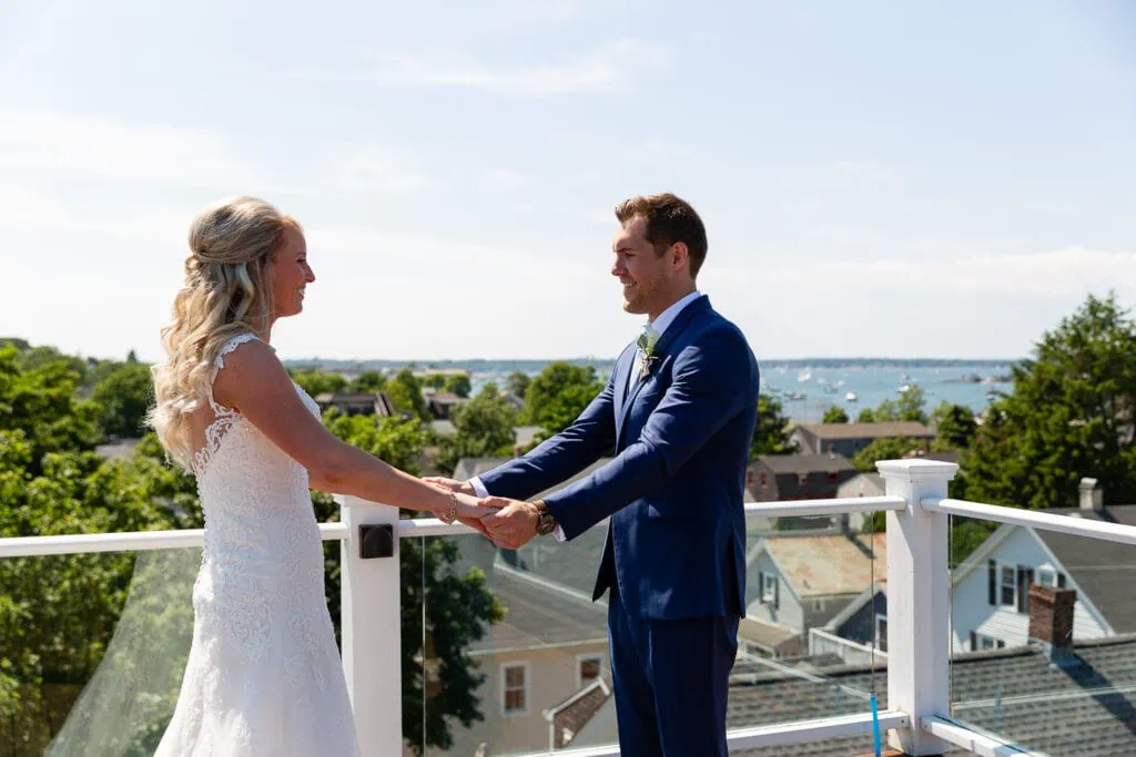 A bride and groom hold hands on a roof deck