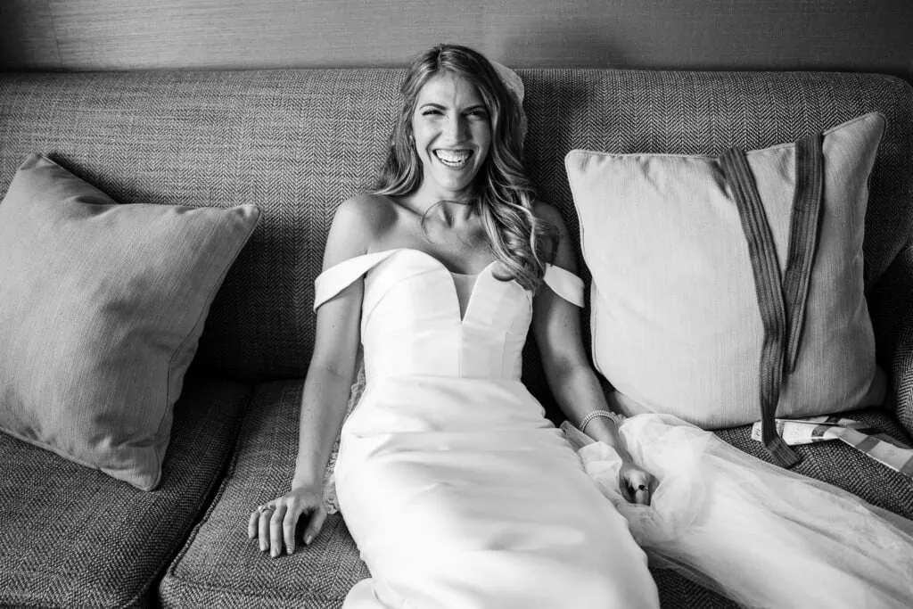 A bride smiling and sitting on a couch