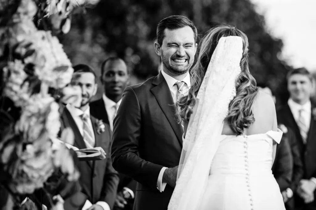 A groom smiles big during a wedding ceremony