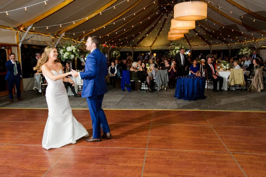 A bride and groom dancing under a tent