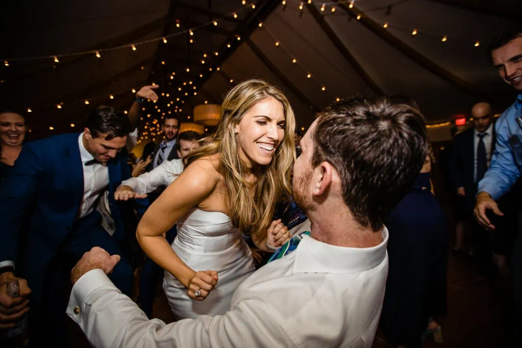 A bride smiling at a man as they dance
