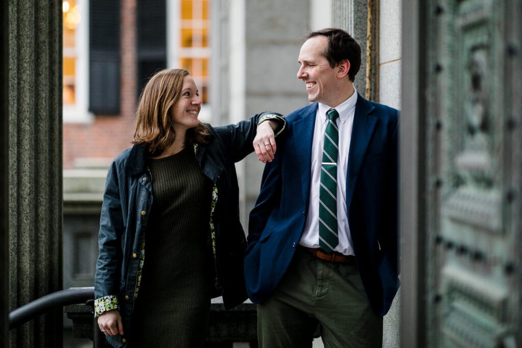 A woman jokingly rests her arm on a mans shoulders during their downtown providence ri engagement photo session