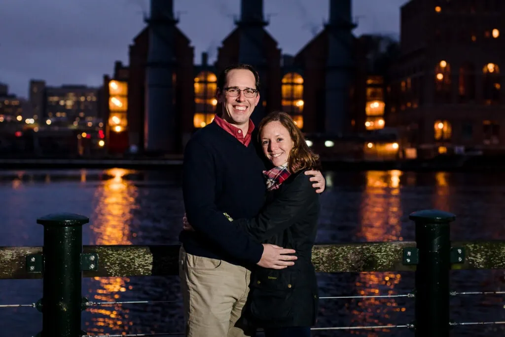 A couple posing for an engagement photos at night in front of the providence power plant