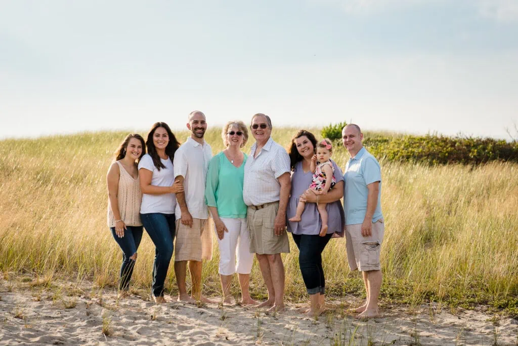 7 adults and 1 child pose for an extended family photo in the beach dunes