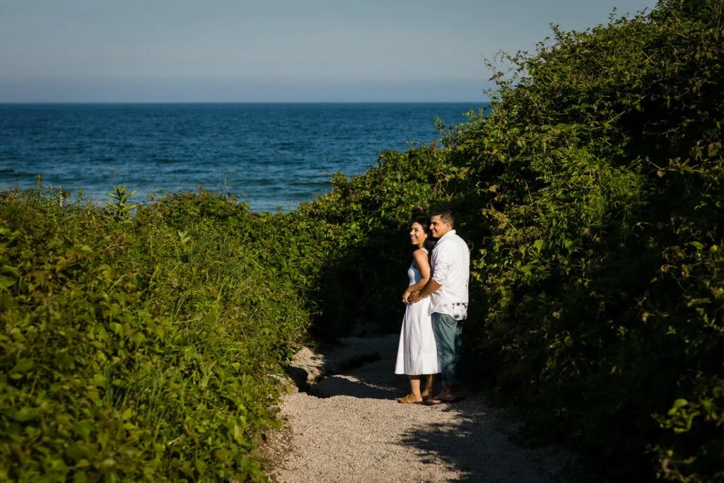 A man and woman cuddle on the beach path to east beach in watch hill rhode island