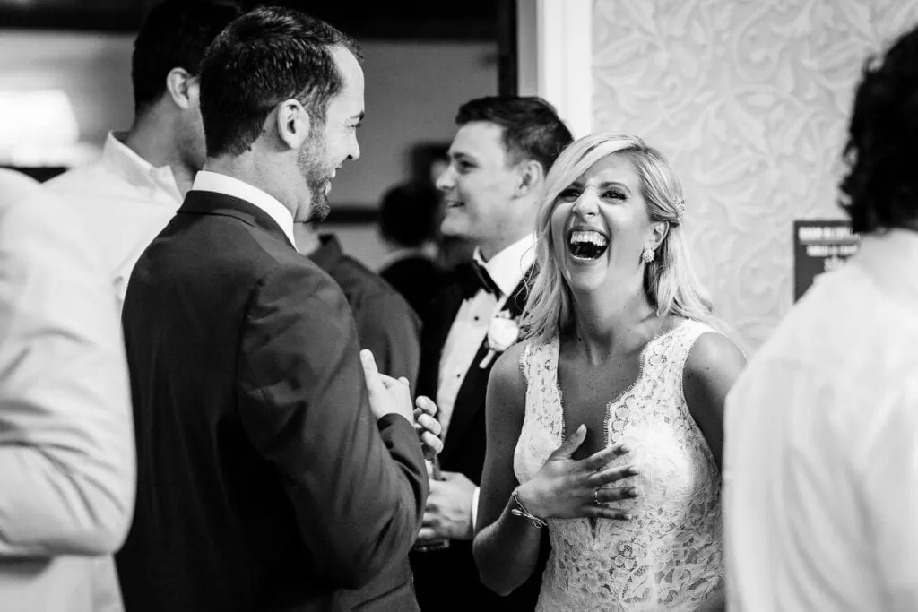 A bride laughs and clutches her chest