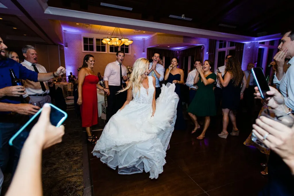 A bride twirls her dress in the middle of a dance circle