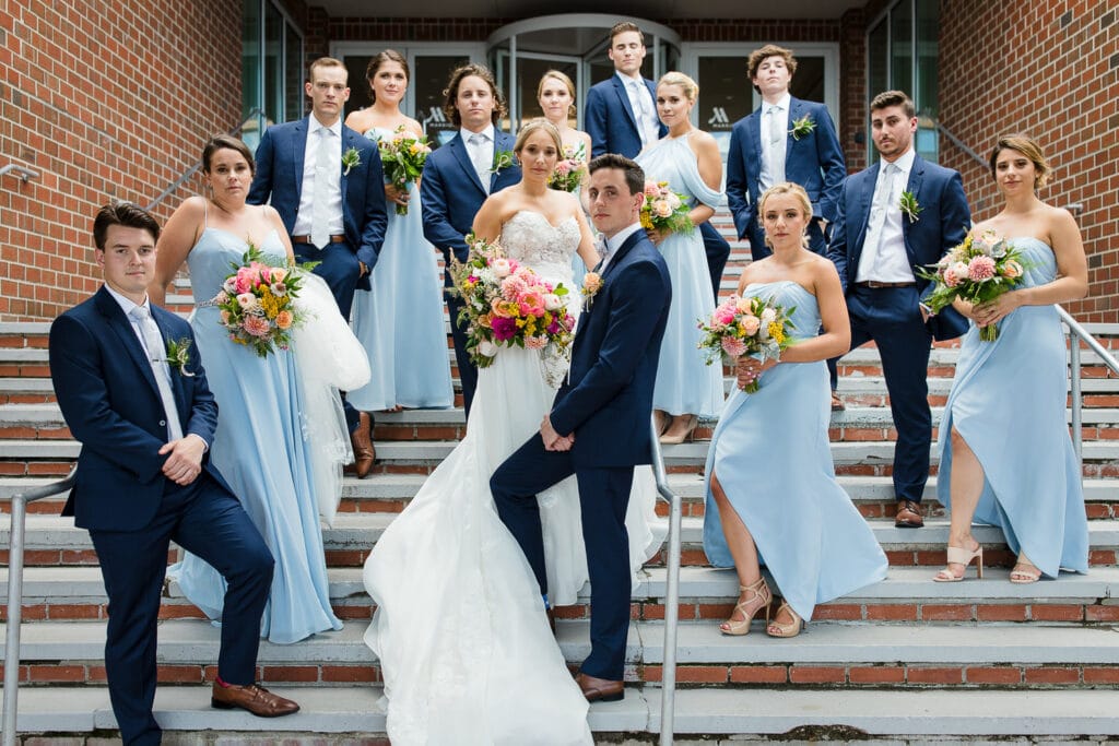 A bridal party posed on the stairs of the Newport Marriott