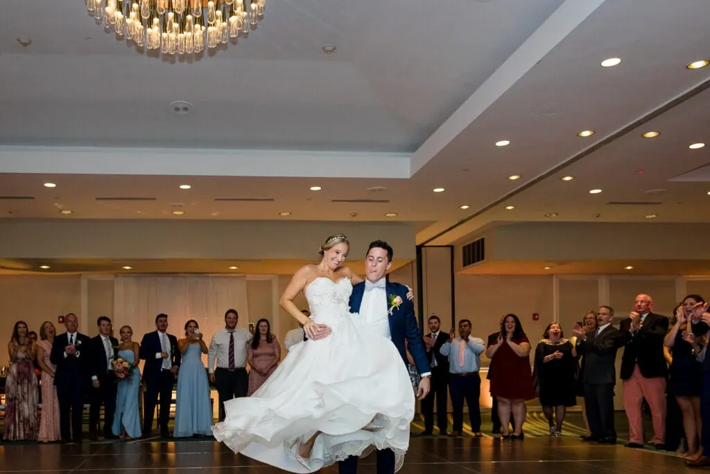 A groom picks up and twirls his bride on the dancefloor of their newport marriott wedding