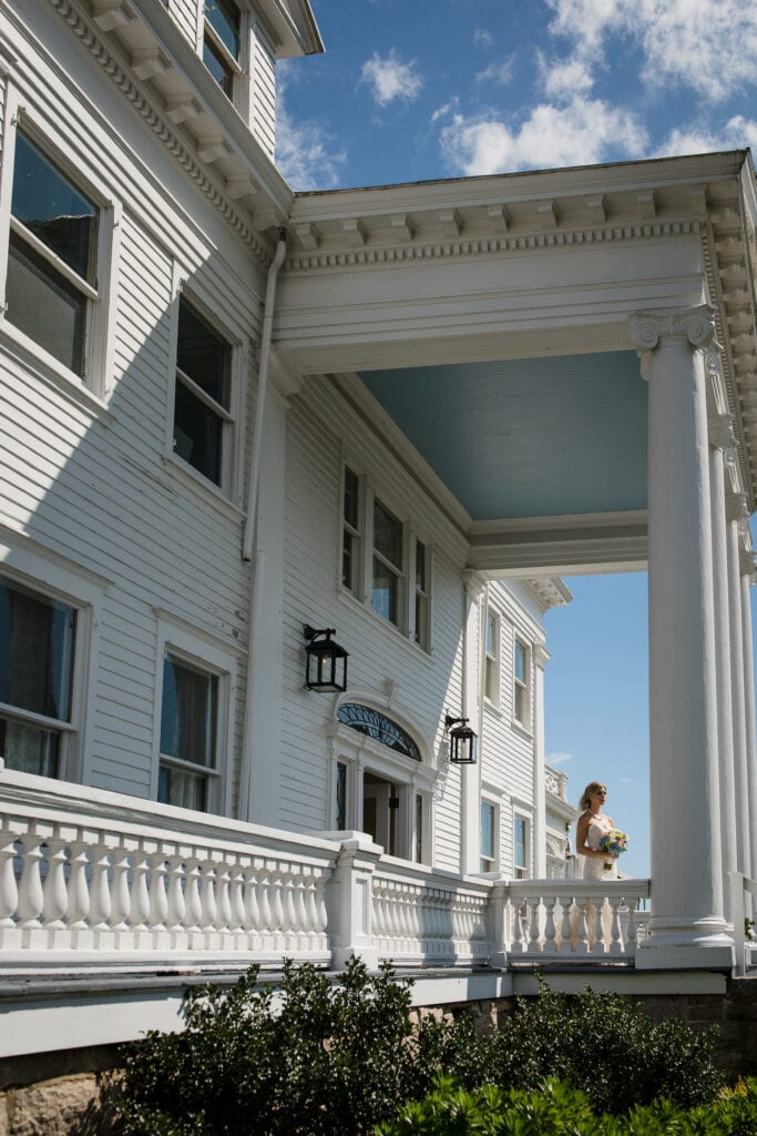 Bride standing on the porch at Haley Mansion in Mystic, CT