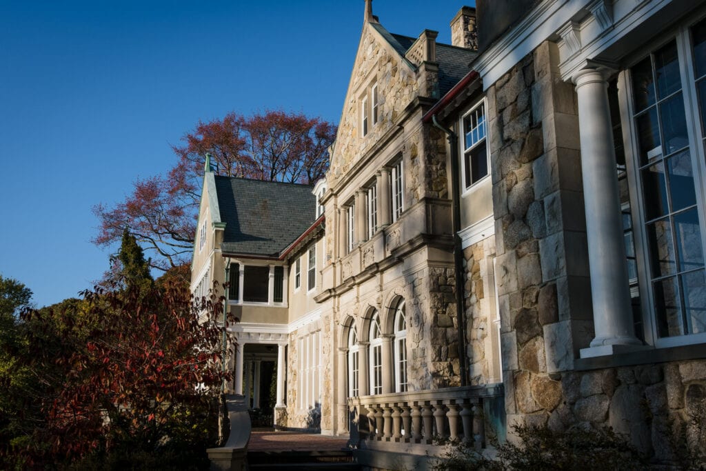 An outdoor photo of the exterior of the blithewold mansion and patio