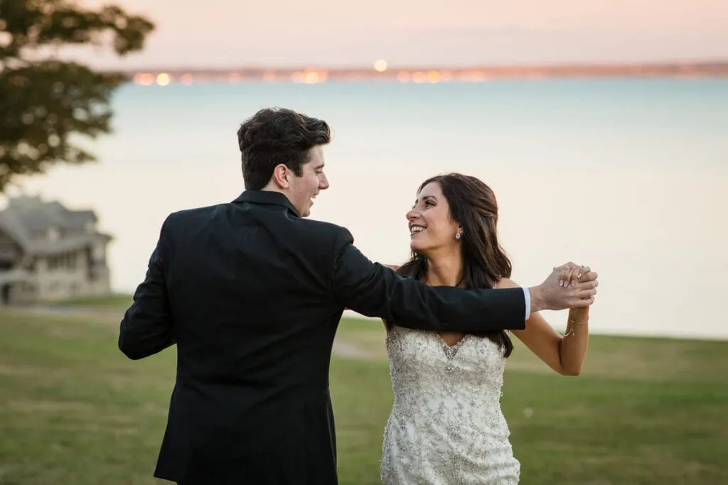 A bride and groom perform a coreographed dance by the ocean