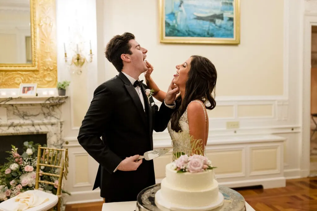 A bride and groom feed each other cake at their wedding