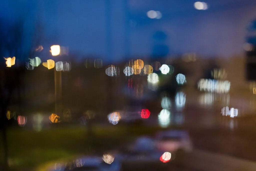 Out of focus street lights seen through a rainy window