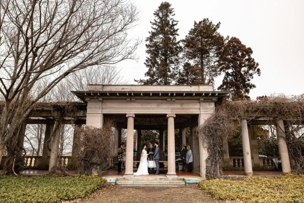 A couple getting married under the pergola in the Italian garden at Harkness Park