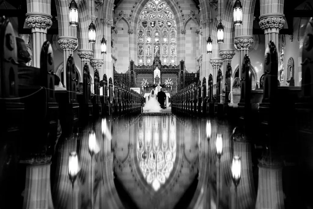 A bride and groom kneel at the alter of Saint Mary's church in Newport during their wedding ceremony