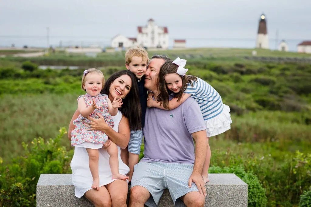 A family of five sit on a bench in Narragansett during a rhode island family photography session