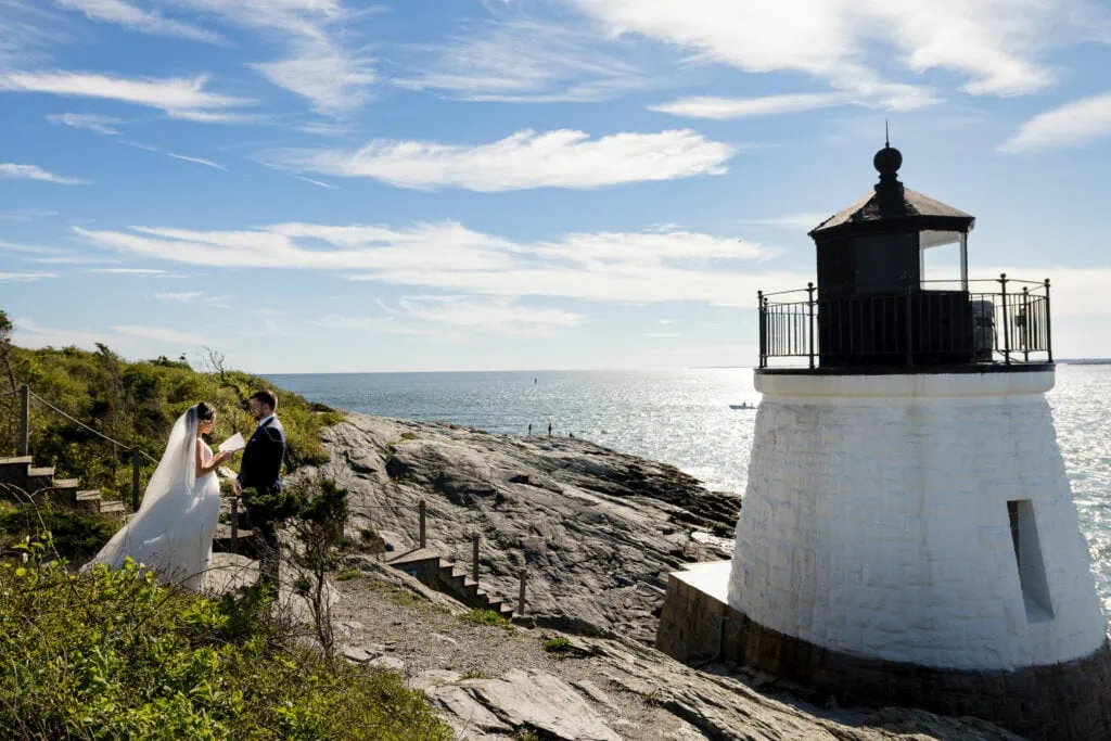 A bride and groom reading vows by the Castle Hill Lighthouse one of the best wedding venues in rhode island