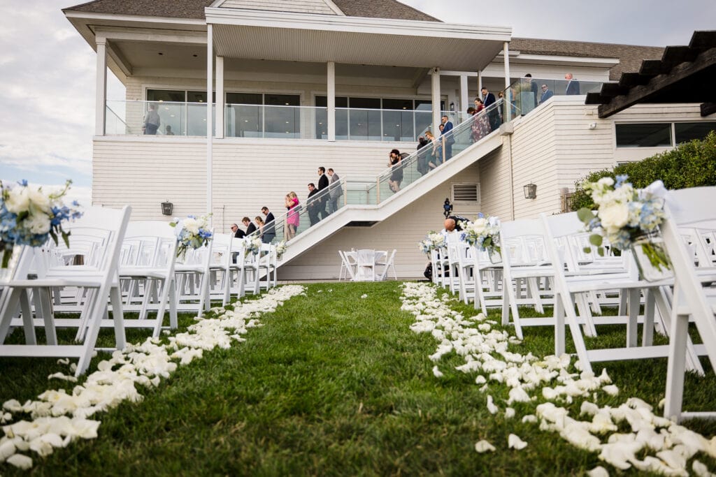 Guests make their way down a staircase to an outdoor wedding ceremony