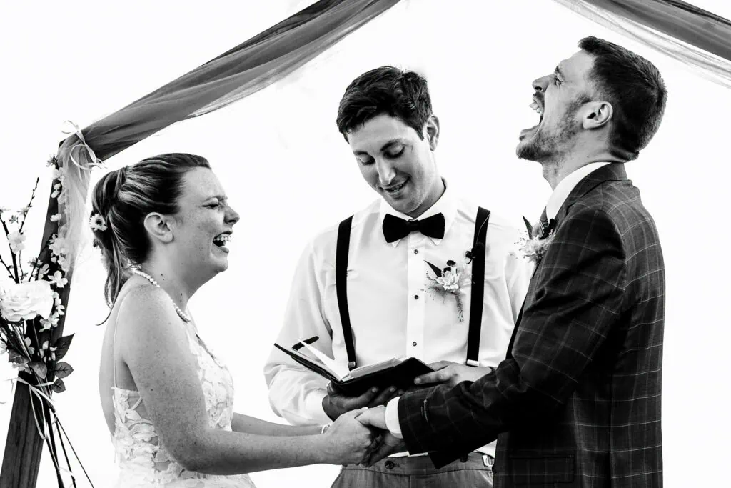 A photographer in RI captured a moment at a wedding where the bride and groom are laughing hysterically