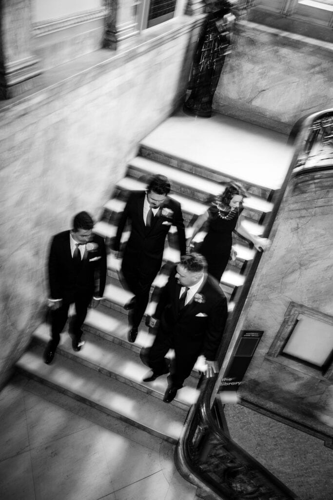 Three men and woman walking down stairs