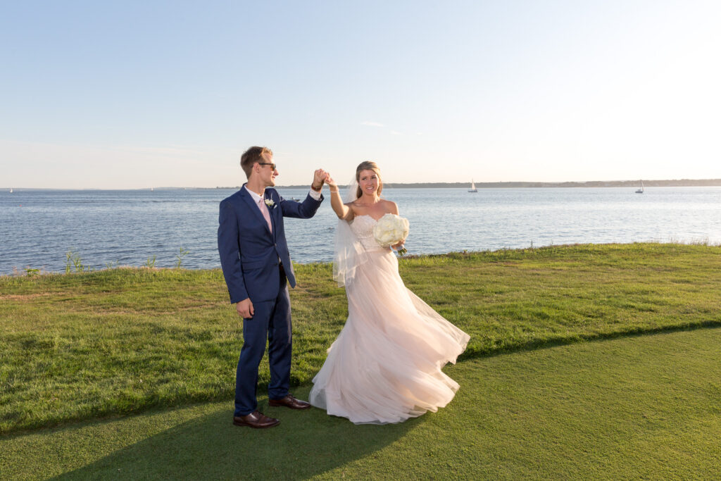 A bride and groom dancing by the ocean