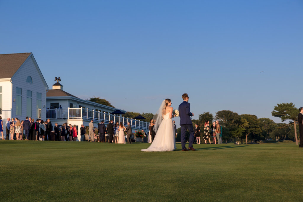 A bride and groom traverse a putting green to their cocktail hour